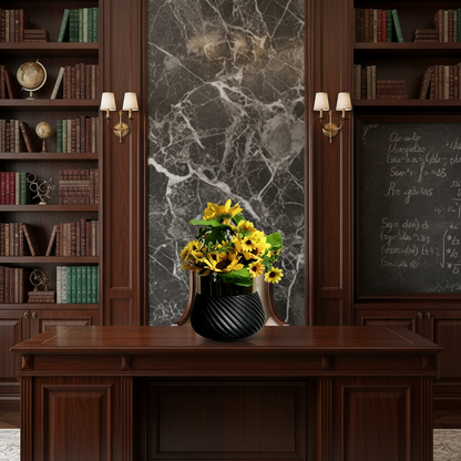 Wooden desk with a vase of yellow flowers in a room with bookshelves and a marble wall.